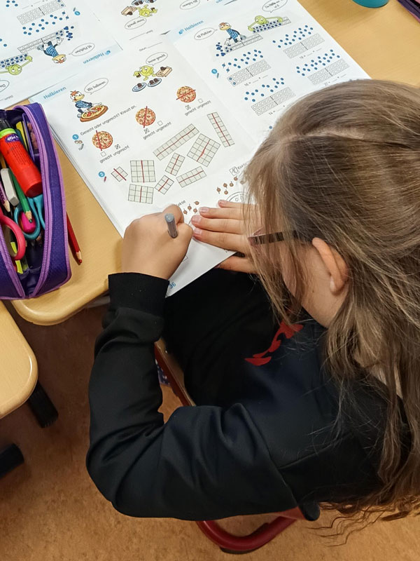 Ein Schulkind konzentriert sich im hellen Unterrichtsraum der Grundschule Schortens – ein Ort zum Fördern, Fordern und Entdecken.